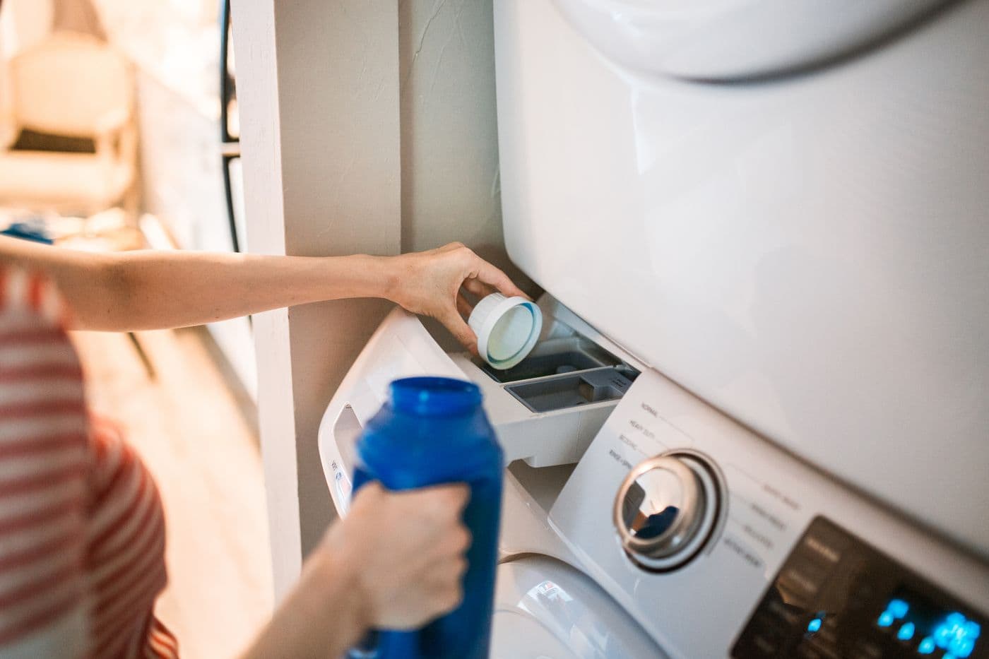 Person loading detergent into a washing machine